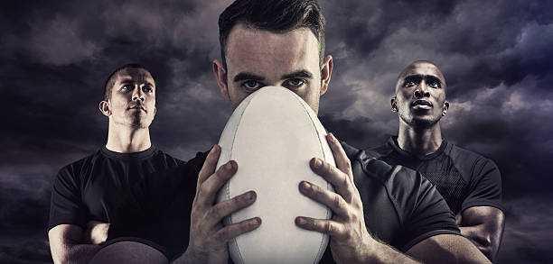 Composite image of tough rugby player holding ball