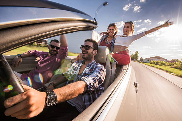 istock Happy friends having fun while driving convertible car. 490682566