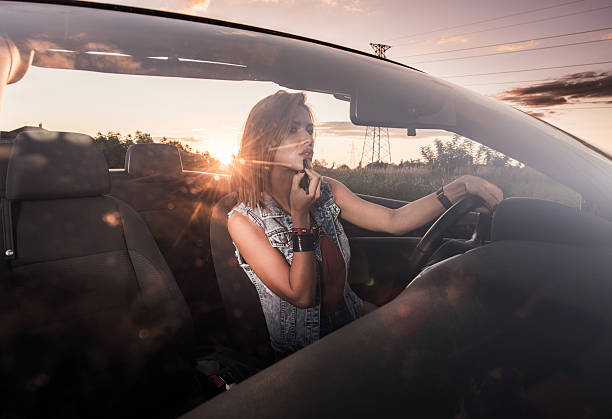 istock Young woman doing her make-up in convertible at sunset. 490682924