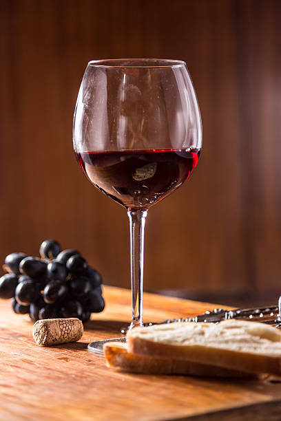 istock Red wine against wooden background 490685464