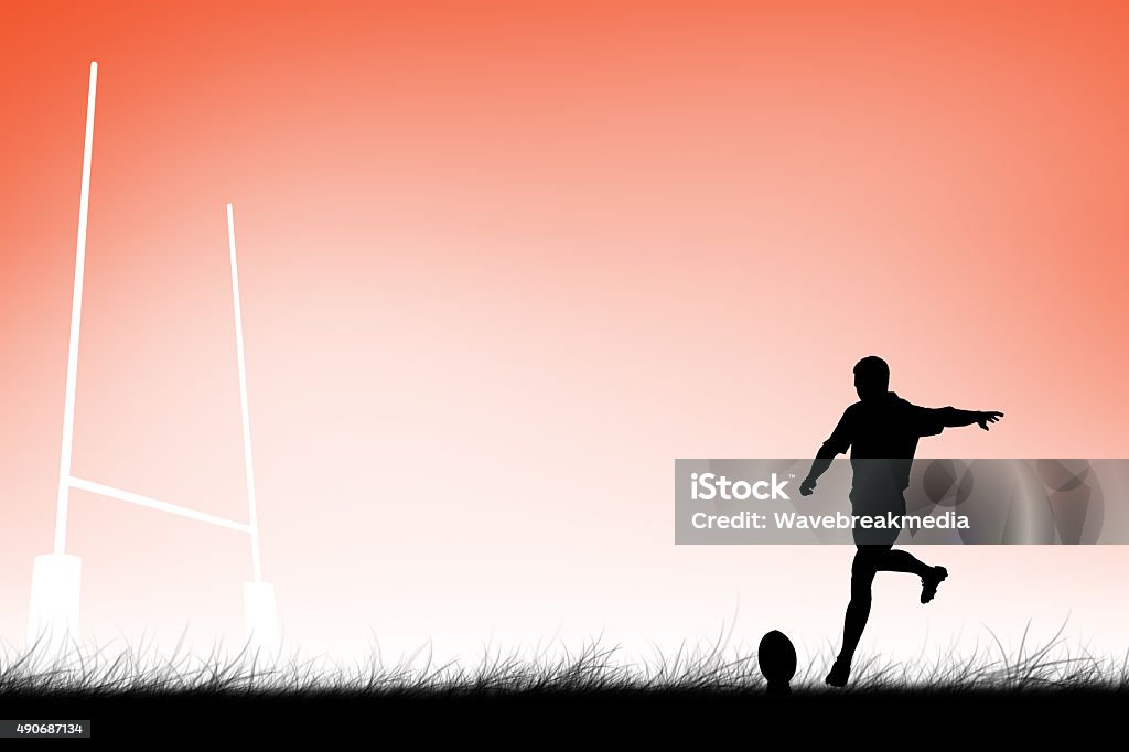 Composite image of rugby player doing a drop kick Rugby player doing a drop kick against orange 20-29 Years Stock Photo