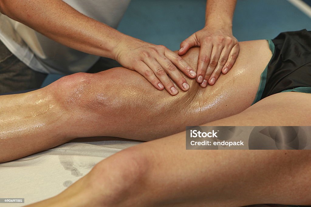 hands massaging athlete's thigh after running Massaging Stock Photo