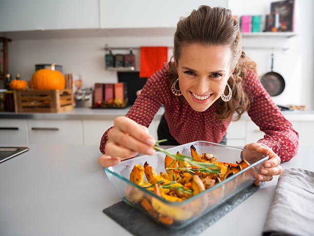 istock Smiling elegant woman preparing roasted pumpkin dish 490691308