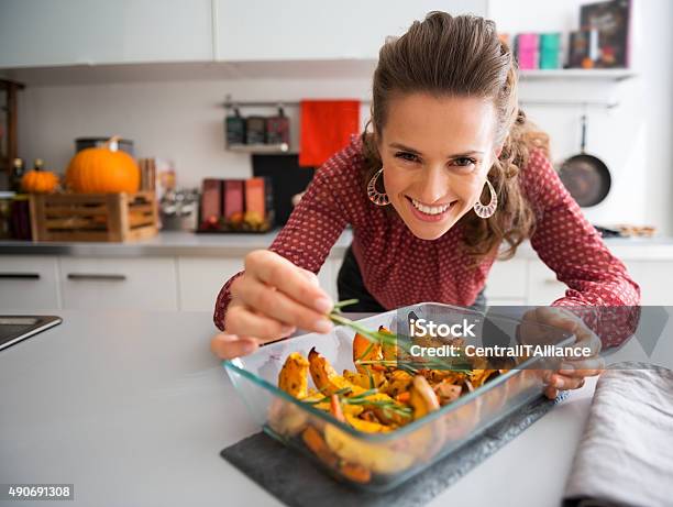 Smiling Elegant Woman Preparing Roasted Pumpkin Dish Stock Photo - Download Image Now