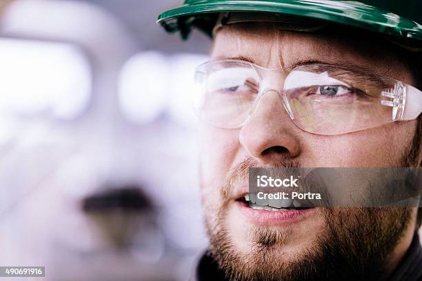 Thoughtful Professional Wearing Protective Eyewear Stock Photo - Download Image Now - Hardhat, Close-up, Human Face