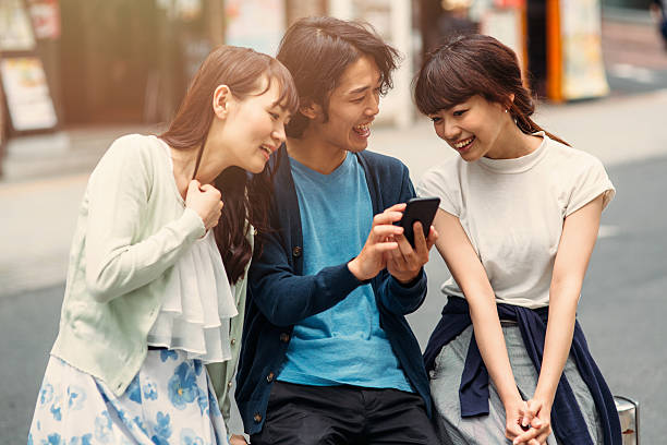 istock Happy japanese friends surfing the net 490692198