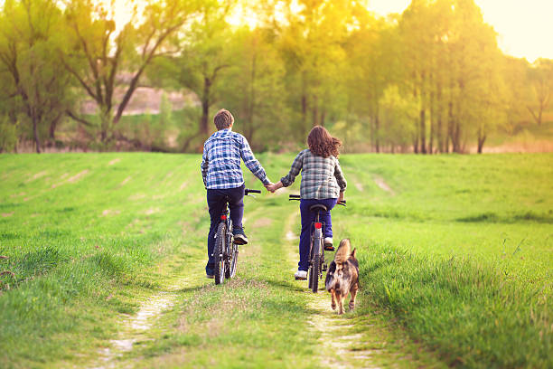 istock Young couple ride bicycles in the meadow 490692983