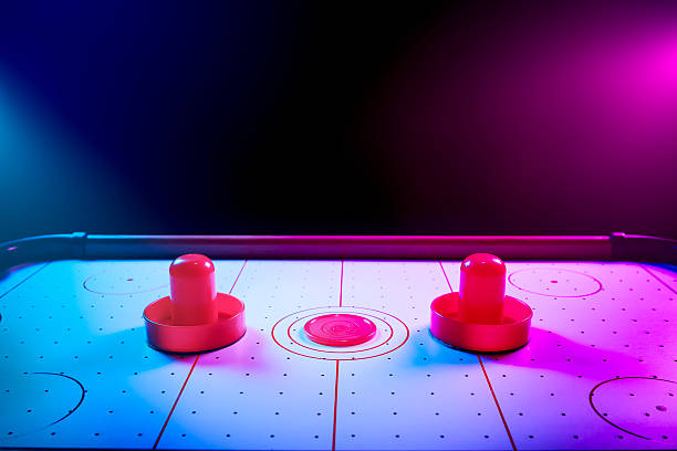 istock Dramatic lit air hockey table with puck and paddles 490693691