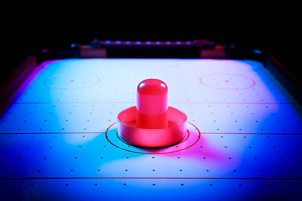 istock Dramatic lit air hockey table with puck and paddles 490694657