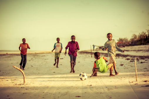 Zanzibar, Tanzania - October 13, 2013: Local kids playing soccer on the beach of fisherman's village Pwani Mchangani of Zanzibar.