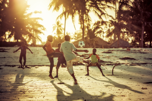 Zanzibar, Tanzania - October 13, 2013: Local kids playing soccer to sunset on the beach of fisherman's village Pwani Mchangani of Zanzibar.