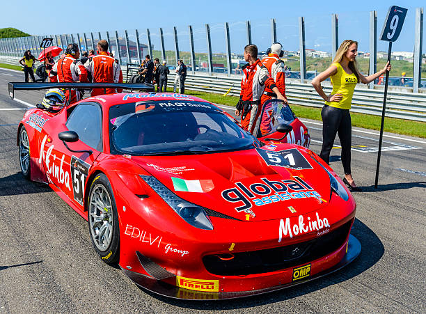 Ferrari 458 Italia GT3 at the start grid Zandvoort, The Netherlands - July 7, 2013: AF Corse Ferrari 458 Italia GT3 on the start grid at the Zandvoort race track during the 2013 FIA GT race. The car is participating in the 2013 FIA GT championship. People in the background are talking and looking at the cars. A grid girl is standing next to the car on the right. spokesmodel stock pictures, royalty-free photos & images