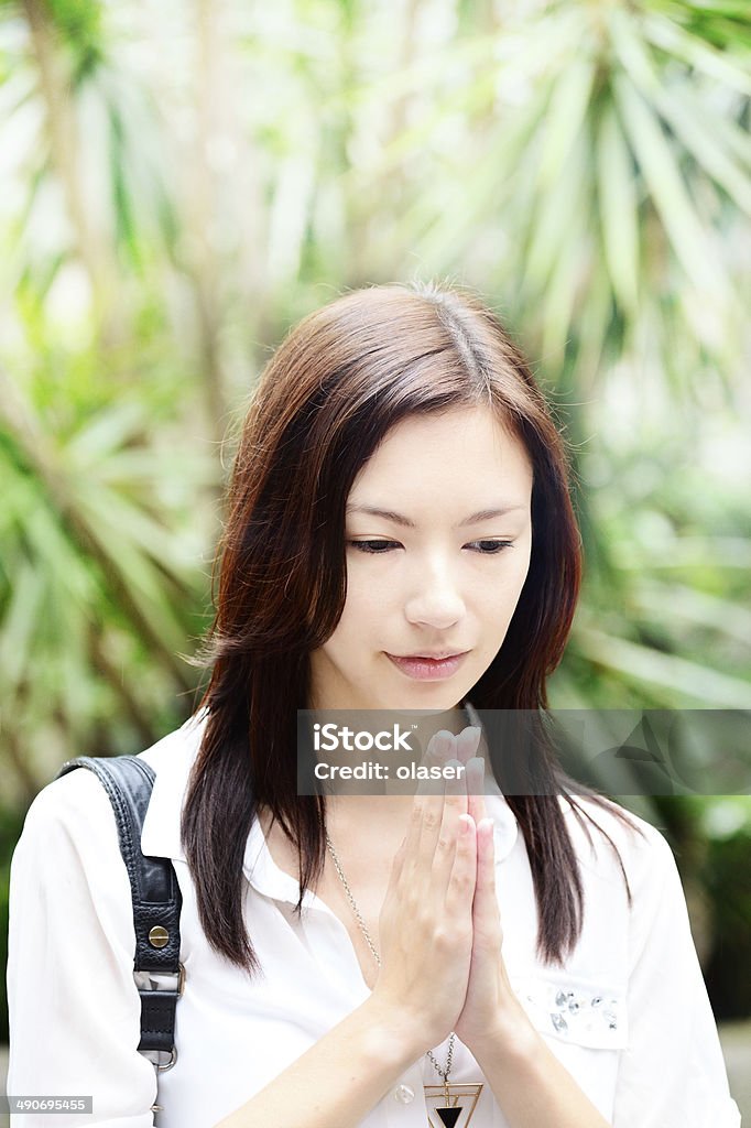 Asian woman in business clothes praying Hong Kong, outside temple with smoke sticks / candles Adult Stock Photo