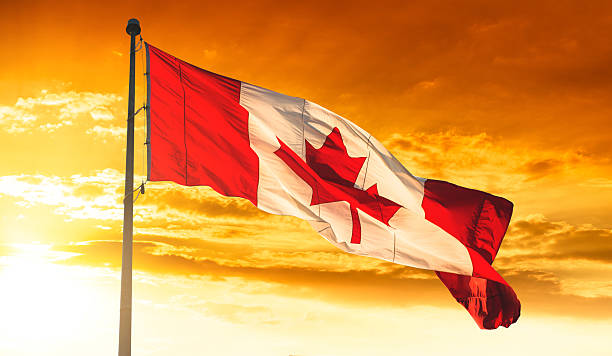 istock canadian flag waving on the sky at sunset 490697020