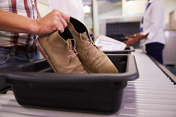 man putting shoes into tray for airport security check - airport security bildbanksfoton och bilder