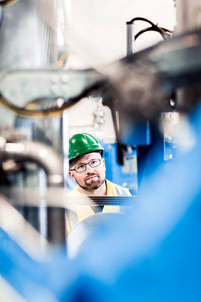 istock Manual worker looking at machinery in factory 490717040