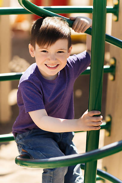 istock happy little boy climbing on children playground 490717396