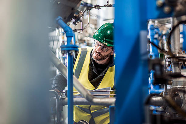 istock Serious manual worker analysing machine parts at factory 490717500