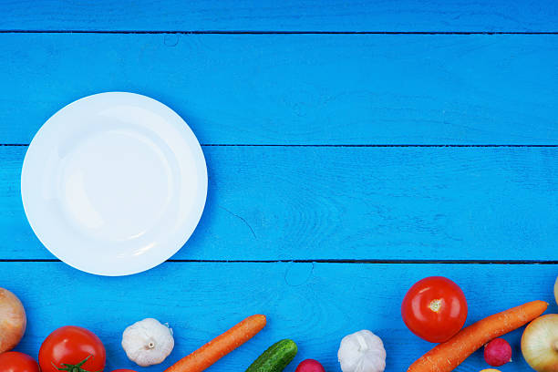 istock Colorful fresh vegetables and white plate on table 490718160
