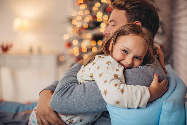 père et son adorable fille en face de noël trois. - bed child smiling people photos et images de collection