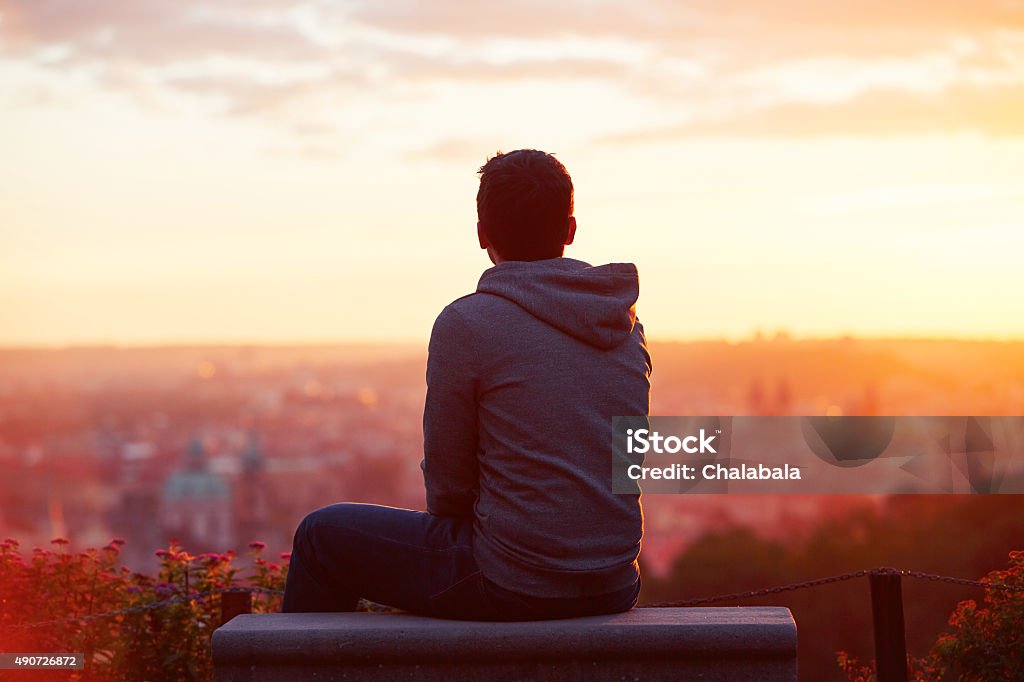 Man at the sunrise Young man is looking at the sunrise Men Stock Photo