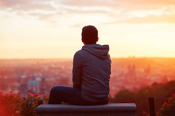 Man at the sunrise Young man is looking at the sunrise park bench photos stock pictures, royalty-free photos & images