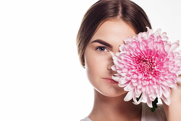 istock Young girl with chrysanthemum flower on half face 490728776