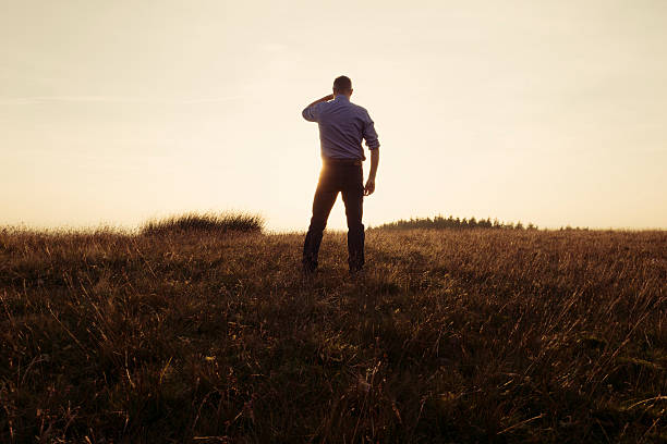 istock Man Stood in the countryside looking at the sunset 490729124