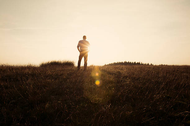 istock Man Stood in the countryside looking at the sunset 490729266