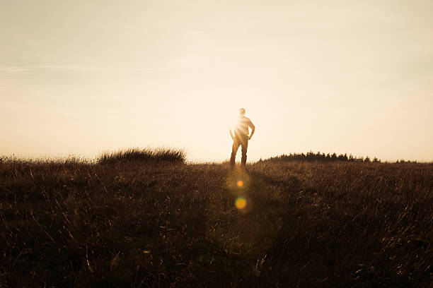 istock Man Stood in the countryside looking at the sunset 490729354
