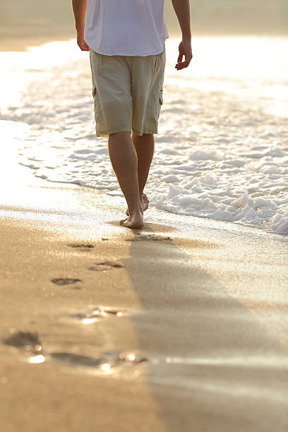 istock Back view of a man legs walking on the beach 490729936