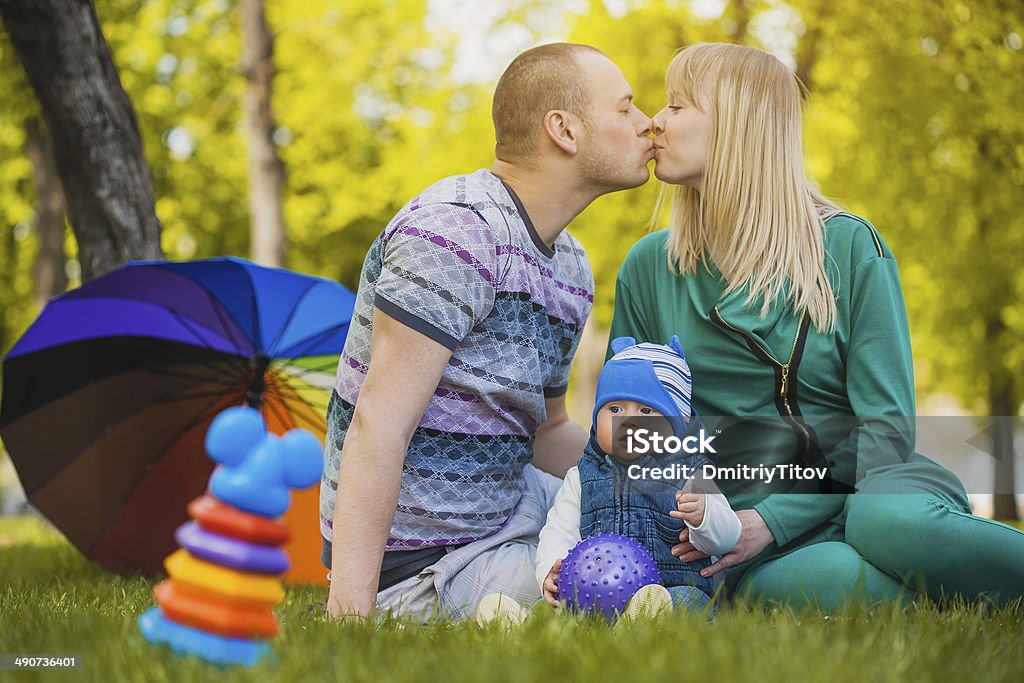 Happy family are plaing in the park Happy family are plaing with their baby in the park Adult Stock Photo