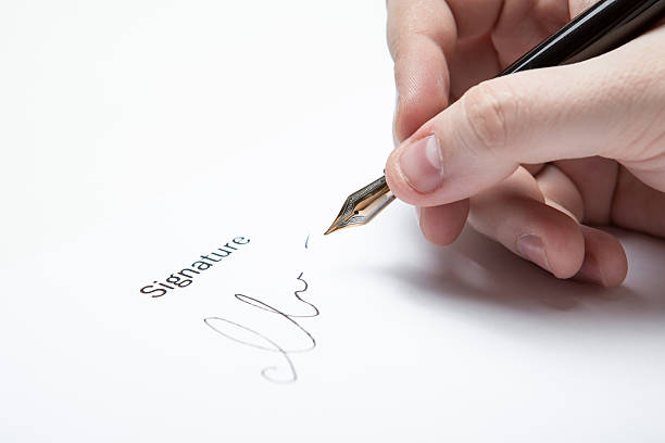 istock pen in the man's hand and signature 490736511