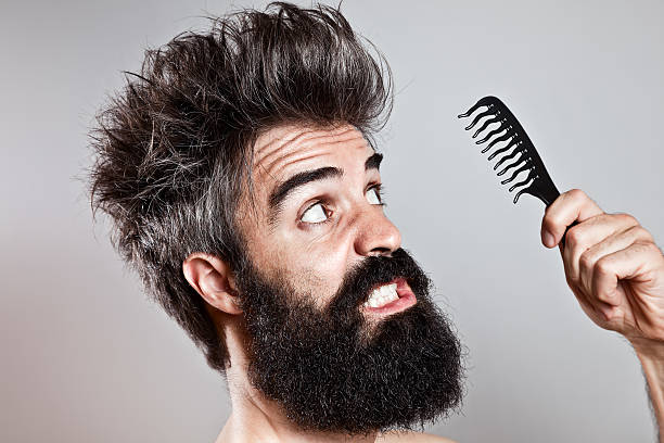 istock Bearded man with messy hair staring at a ruined comb 490736929