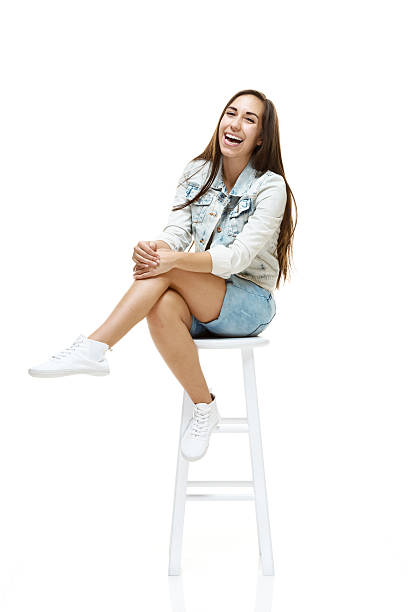 istock Cheerful woman sitting on stool & wearing jacket 490737013