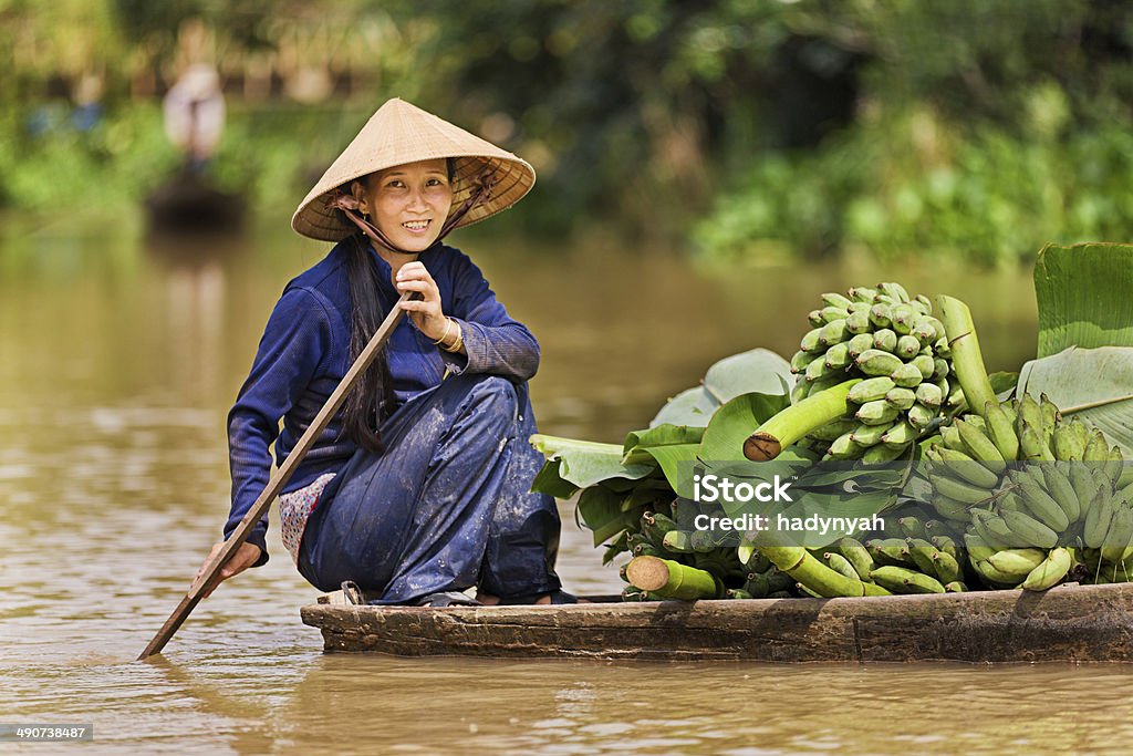 Vietnamese woman rowing  boat in the Mekong River Delta, Vietnam Vietnamese fruits seller - woman rowing boat in the Mekong river delta & selling bananas, Vietnam. Mekong River Stock Photo