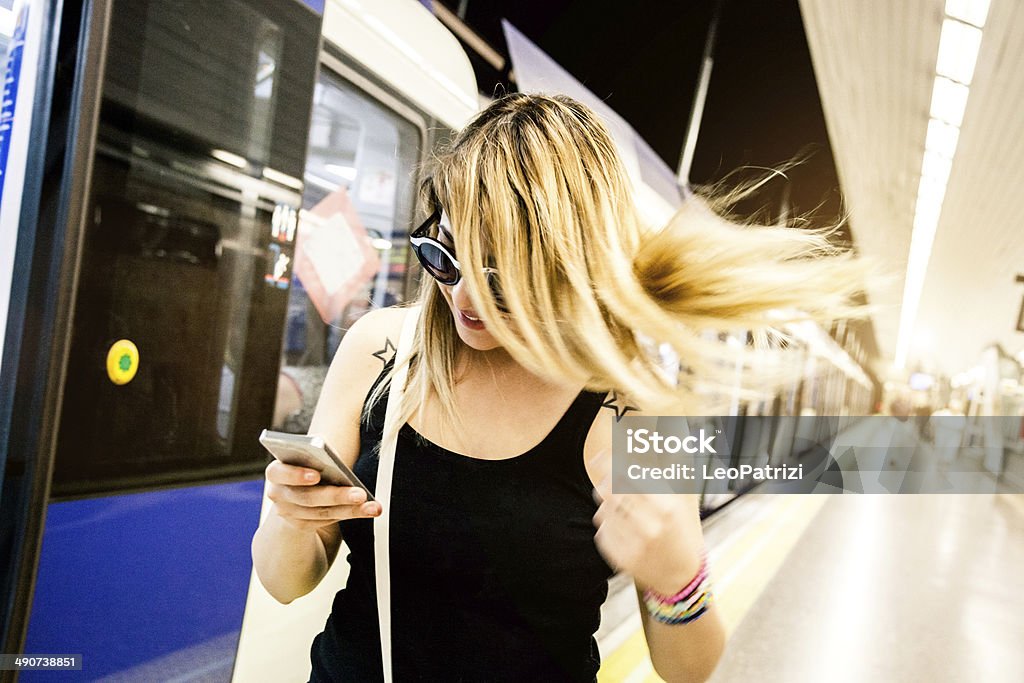 Texting on the subway platform Texting on the subway platform in Madrid, Spain. 16-17 Years Stock Photo