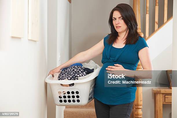 Stressed Pregnant Woman Doing Chores At Home Stock Photo - Download Image Now - Pregnant, Sadness, Carrying