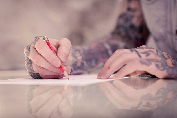 istock Artist's tattooed hands drawing on paper in studio 490747904