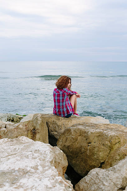 istock Back of a girl sitting on a pier 490748066