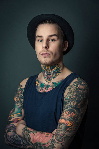 jovem tattooed homem em pé braços cruzados - arm tattoo - fotografias e filmes do acervo