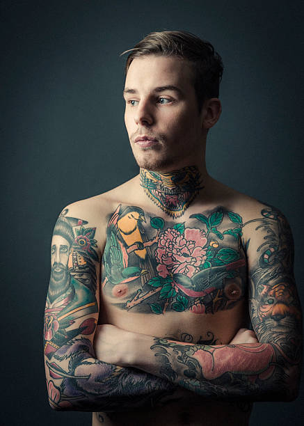 istock Thoughtful shirtless tattooed man standing arms crossed 490749014