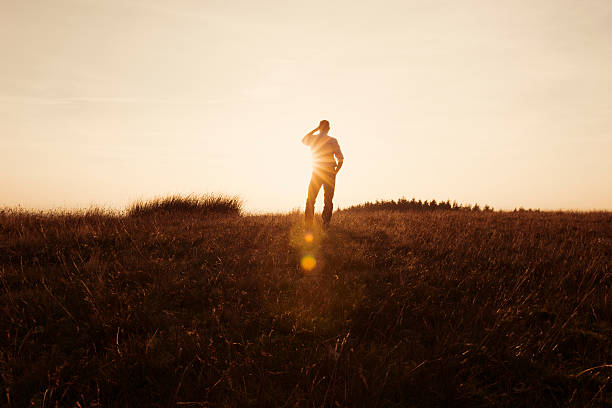 istock Man Stood in the countryside looking at the sunset 490751314
