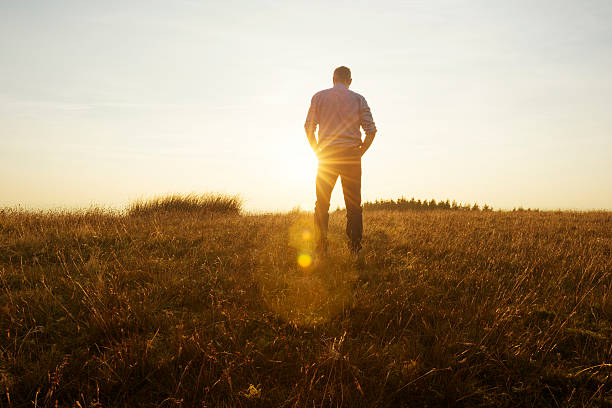 istock Man walking in the countryside looking at the sunset 490751704