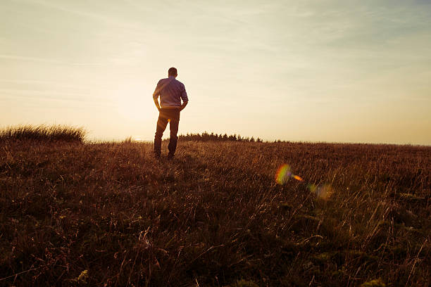istock Man walking in the countryside looking at the sunset 490751906