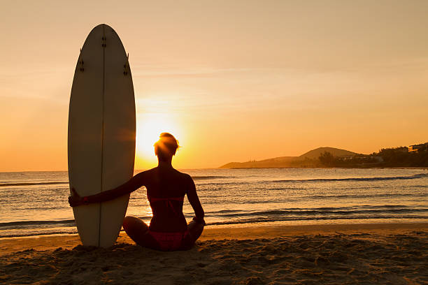istock surfer girl in bikini surfboard on a beach at sunset 490773903