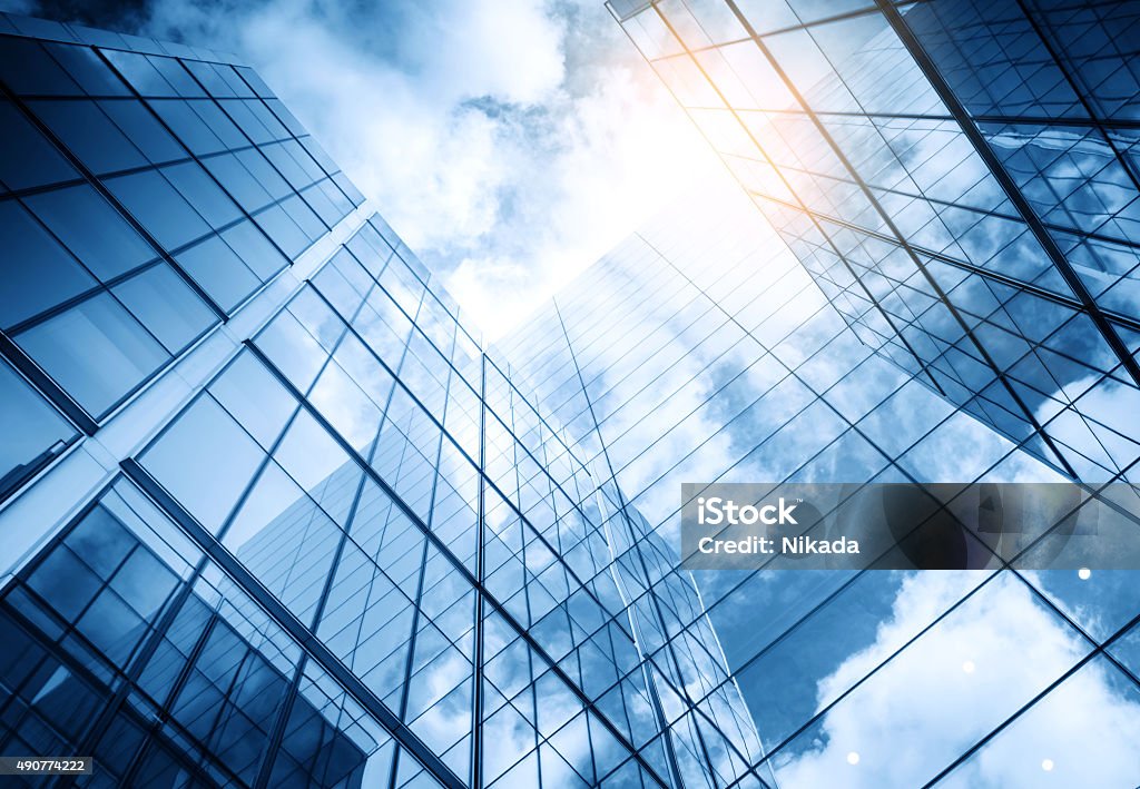 view of a contemporary glass skyscraper reflecting the blue sky Building Exterior Stock Photo