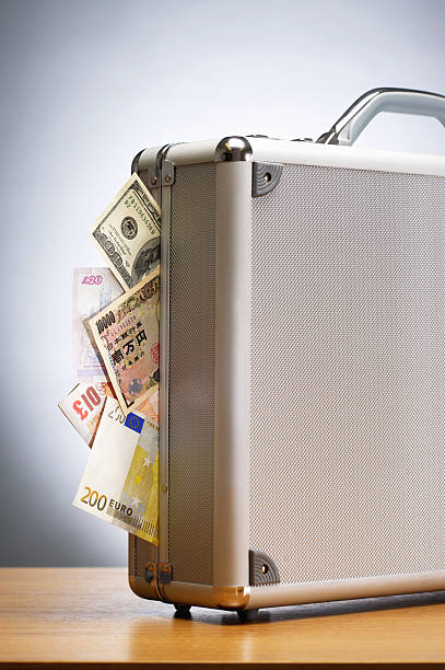 istock Metal suitcase full of cash on table 490774983