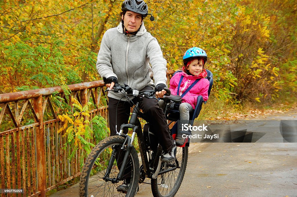 Father and kid on bike in autumn park Father and kid on bike, cycling in autumn park Child Stock Photo