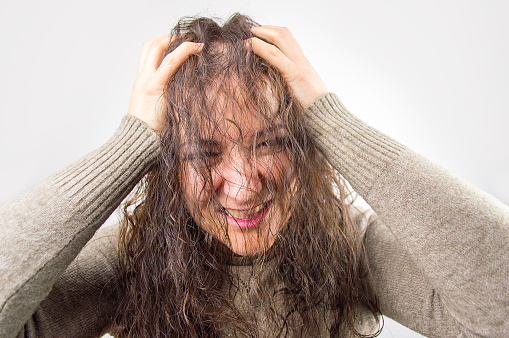 woman looking at the camera looking perturbed by her damaged hair